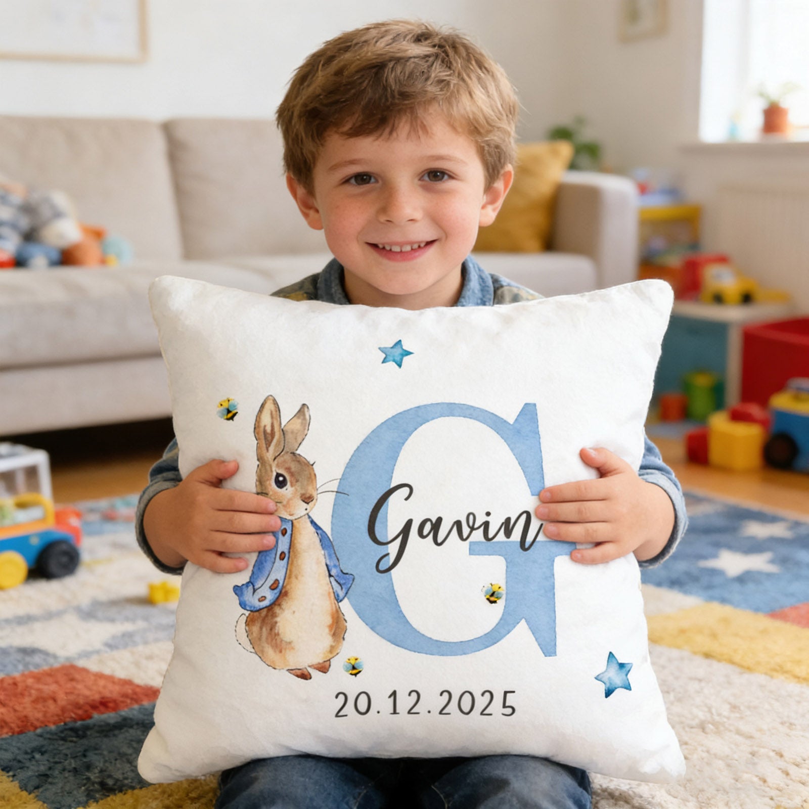 Smiling boy happily holding personalized Peter Rabbit bunny pillow with custom name and date, perfect keepsake gift for kids