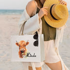 Woman holding custom highland cow tote bag at beach, stylish large capacity daily carry bag